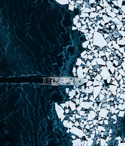 Photograph from a birds eye view of boat in the sea with ice image