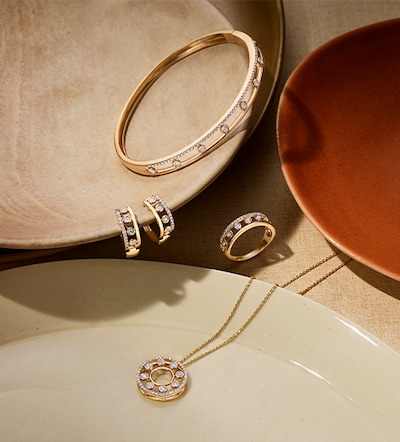 Image of diamond necklace earrings bangle and ring in terracotta coloured bowl. Tap to shop all diamond jewellery image