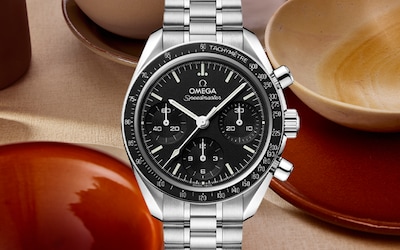 Image of Omega speedmaster on terracotta background. tap to shop all watches image