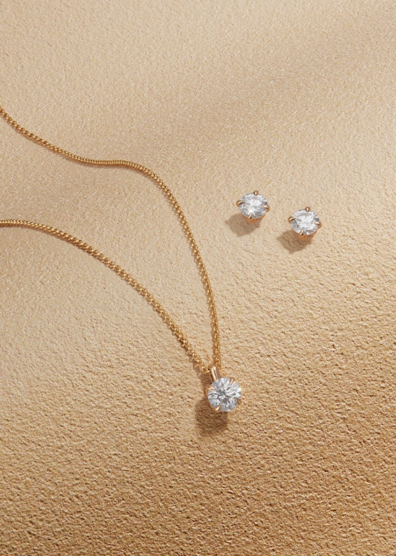 Goldsmiths Signature Diamond Yellow Gold Jewellery on sandy background