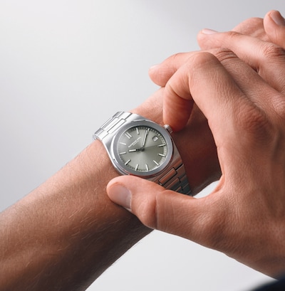 Image of men' hand wearing Raymond Weil silver dial watch image