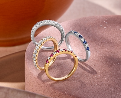 Image of mix cut and colour eternity rings on cream background. tap to shop all eternity rings image